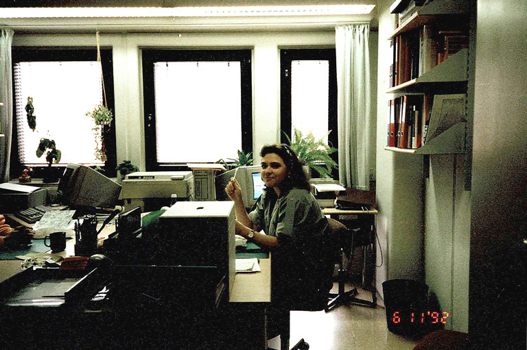 Päivi Lundahl vanhassa toimistohuoneessa jossa paljon koneita ja tavaraa.