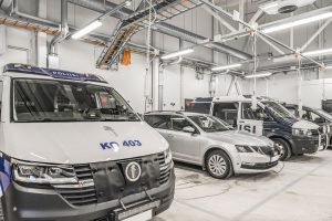 Poliisiaseman autohallissa neljä poliisiautoa pysäköitynä ja latauksessa.