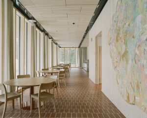 Käytävä, jonka varrella pöytiä ja tuolia.