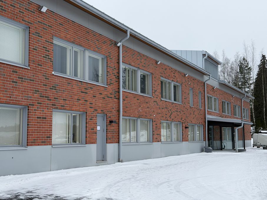 Punatiilinen kaksikerroksinen kasarmirakennus talvella.