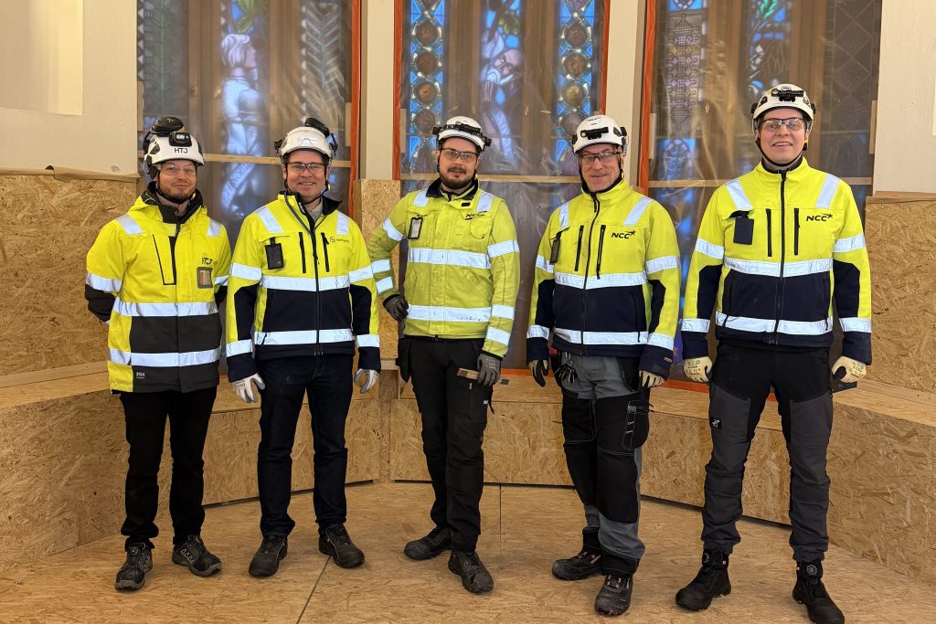 Kuvassa viisi rakennustyömaan työntekijää.