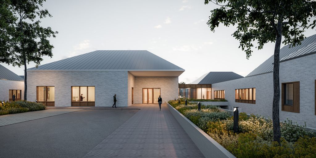 Uudisrakennuksen sisäänkäynnin havainnekuva iltavalaistuksessa.