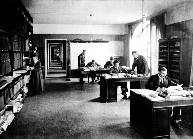 Kuvassa on työhuone, jossa työskentelee tilastollisen päätoimiston henkilöstöä vuonna 1921.